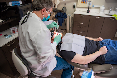 a dentist performing an oral exam on a patient